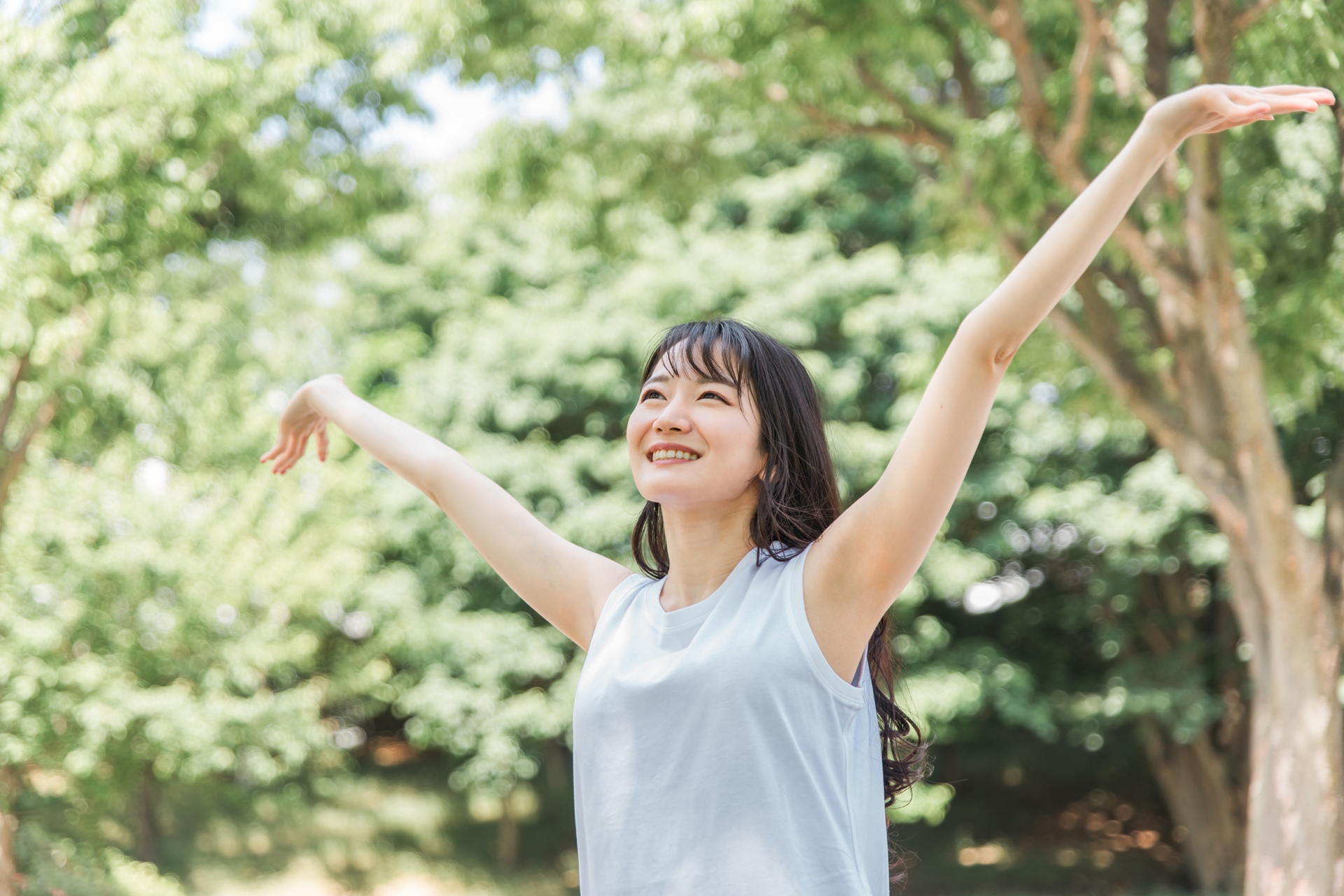 緑の中で深呼吸する女性